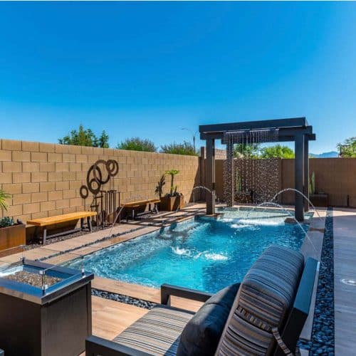 luxury custom pool with rain features and wood paneling