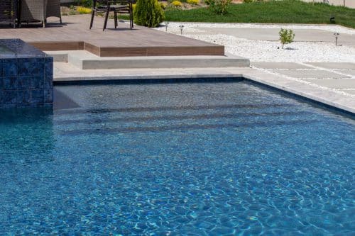 Temecula backyard pool design with waterfall features and neutral color palette