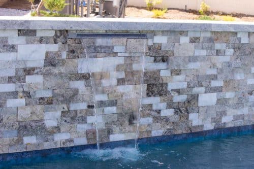 Temecula backyard pool design with waterfall features and neutral tiling