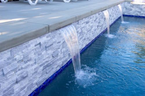 Chino Hills pool design with bright blue tiling accents and waterfall features
