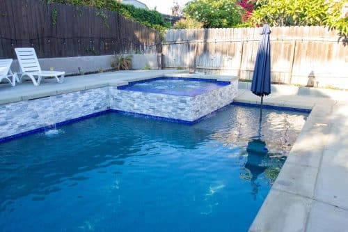 SoCal swimming pool with corner spa and blue tiles
