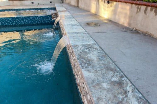 custom backyard pool construction with waterfall features