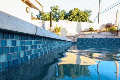 custom backyard pool construction with blue tiling