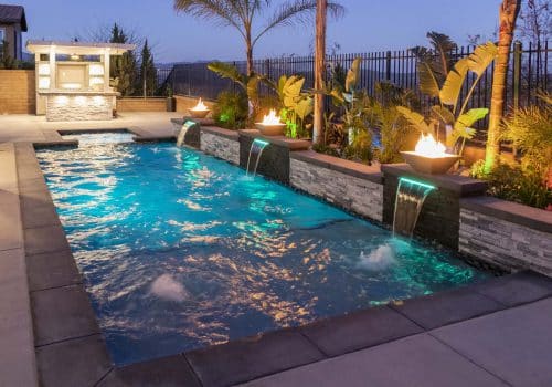night view of luxury SoCal swimming pool with fire features and poolside barbecue kitchen