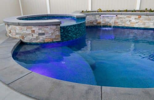 Purple lights in swimming pool with fountains