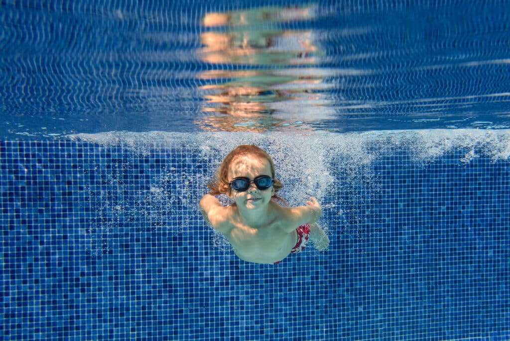 Smiling boy swimming underwater