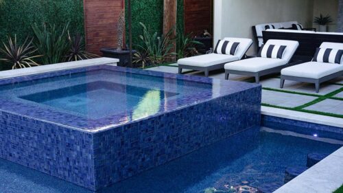 custom backyard pool with a hot tub