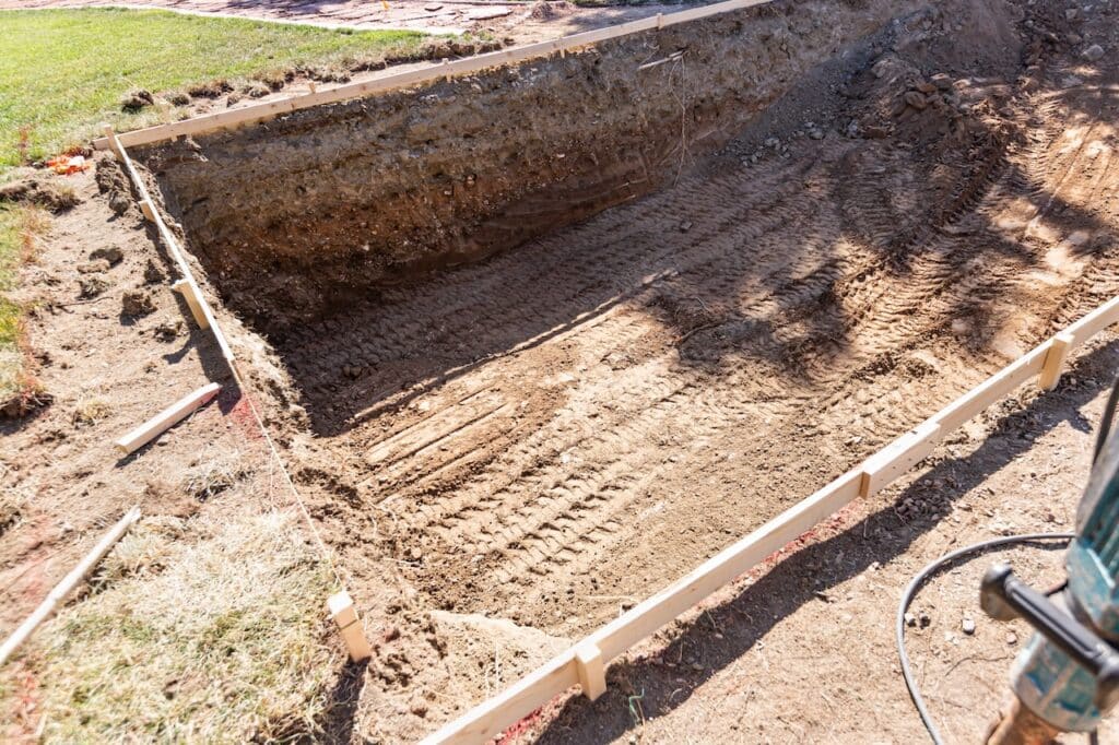 hole dug out in backyard pool for swimming pool installation