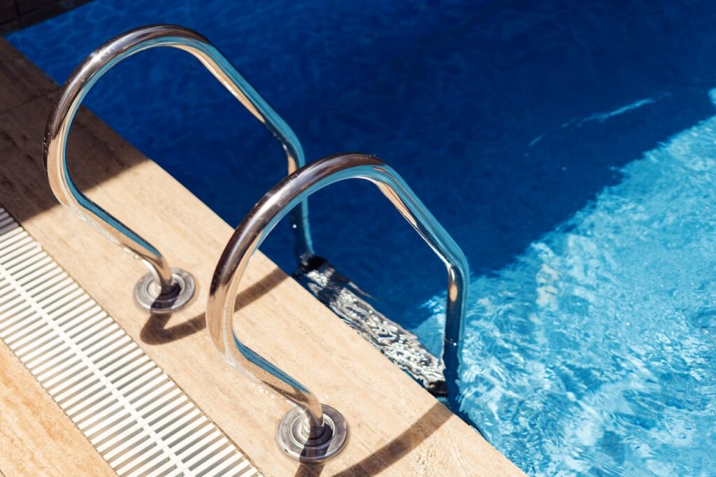 backyard pool with railing to enter the pool