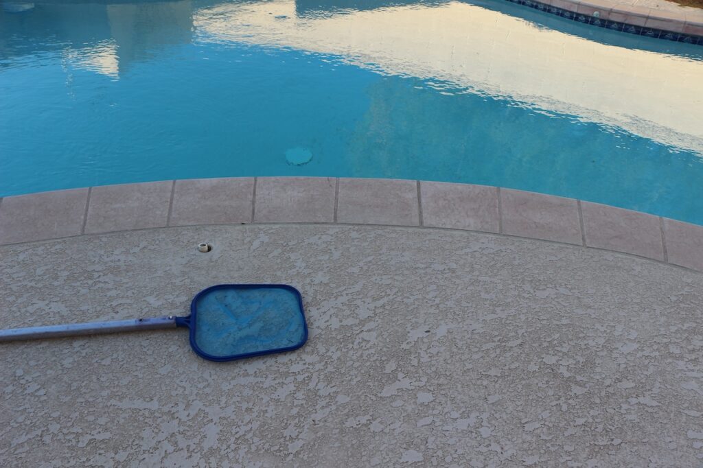 pool skimmer sitting next to swimming pool